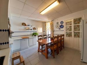 a kitchen with a wooden table and chairs at Casería El Albercón in Mancha Real