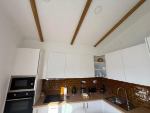 a kitchen with white cabinets and a brick wall at Casa Vila de Frades in Vila de Frades