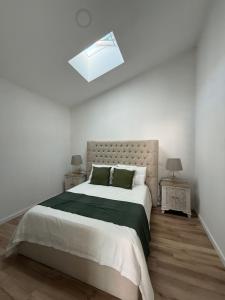 a white bedroom with a large bed and a skylight at Casa Vila de Frades in Vila de Frades