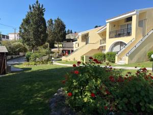a large apartment building with red flowers in a yard at Mediterranean Blue in Kavos