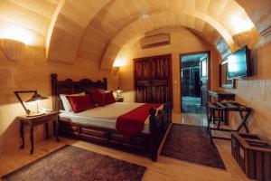 a bedroom with a bed in a room with an arch at Melis Cave Hotel in Ürgüp