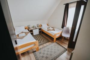 a small room with two beds and a chair at Grádics Panzió in Siculeni