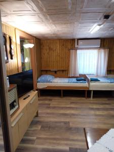 a room with two beds and a flat screen tv at Chata v lese in Olbramkostel