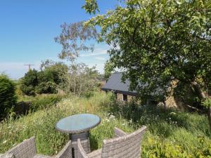 a table and chairs in a field of grass at Overlea Coach House in Birch Vale