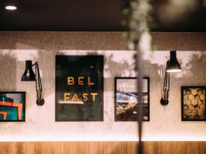 a group of pictures hanging on a wall with lights at ibis Belfast City Centre in Belfast
