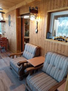 a living room with two chairs and a table at Chata v lese in Olbramkostel