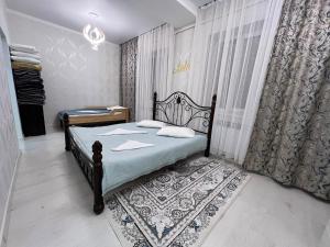 a bedroom with a bed with a rug and a window at Archa Ethno Guest House in Bokonbayevo