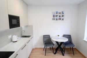 a kitchen with two chairs and a small table at NOVA Apartment - 1 in Klaipėda