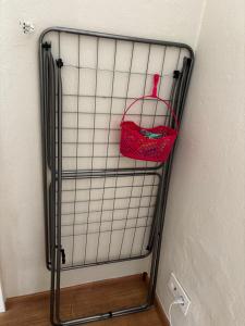 a wire rack with a red purse hanging on a wall at Rosenwohnung in Neustrelitz