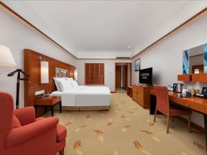 a hotel room with a bed and a desk at Pullman Zhangjiajie Hotel in Zhangjiajie