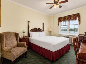 a bedroom with a bed and a chair and a window at Lafayette Hotel Marietta in Marietta +75 photos