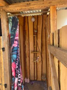 a room with wood walls and a shower curtain at Anno 1782 Unique Romantic Glamping at the Manors Historic Barn in Arnager