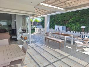 a patio with a table and chairs on it at Villa Pinares de Roche - Piscina privada - Playa a 6 min in Roche