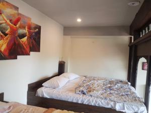 a bedroom with a bed and a painting on the wall at Saadis cottage in Bhurban