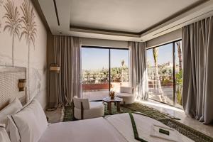 a hotel room with a bed and a large window at Palais Zaitunay in Marrakesh +135 photos