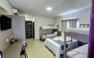a room with two bunk beds and a tv at Hotel da Vila in Vila Bela da Santíssima Trindade