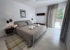 a bedroom with a bed with two towels on it at Villa Pinares de Roche - Piscina privada - Playa a 6 min in Roche