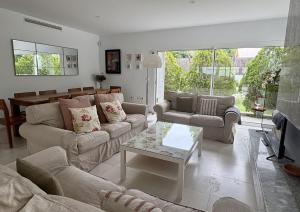a living room with two couches and a table at Villa Pinares de Roche - Piscina privada - Playa a 6 min in Roche +27 photos