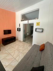 a bedroom with a bed and a flat screen tv at Chalé em Maresias - Quintal Privativo - Pet Friendly 4 Hóspedes in Maresias