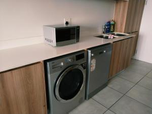 a kitchen with a microwave and a washing machine at Aurevia Properties in Pretoria