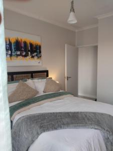 a bedroom with two beds and a painting on the wall at Aurevia Properties in Pretoria +17 photos