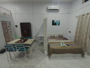 a room with two beds and a table and chairs at Lakhimpur Central Homestay - Unmarried couples not allowed in North Lakhimpur