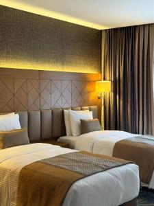 ein Hotelzimmer mit zwei Betten und einer Lampe in der Unterkunft KBF Hotel in Alger