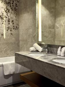 ein Badezimmer mit Waschbecken, Spiegel und Badewanne in der Unterkunft KBF Hotel in Alger