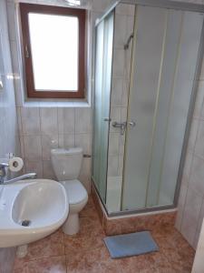 a bathroom with a toilet and a sink and a shower at Pokoje Poniatowka in Nałęczów +10 photos