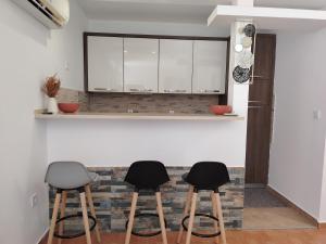 a kitchen with three stools in front of a counter at Maya bay in Kotor