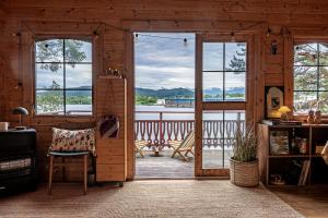 a living room with a door open to a deck at Fjord View Off-Grid Cabin in Ålesund