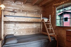 a bunk bed in a log cabin with a ladder at Fjord View Off-Grid Cabin in Ålesund