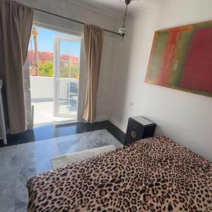 a bedroom with a leopard print bed and a window at Room in Estepona