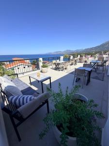 a patio with tables and chairs and the ocean at Apartments Tina in Utjeha