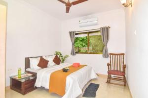a bedroom with a bed and a chair and a window at Diamond Villa - The Dream Stays ll Pvt Pool ll Wi-Fi ll 2AC Rooms in Lonavala +19 photos