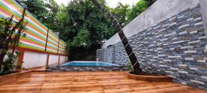 a patio with a swimming pool and a brick wall at Diamond Villa - The Dream Stays ll Pvt Pool ll Wi-Fi ll 2AC Rooms in Lonavala