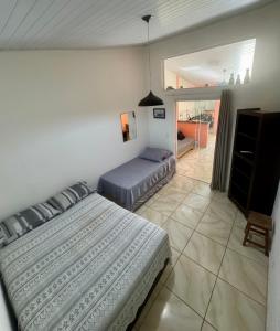 a bedroom with two beds and a balcony at Chalé em Maresias - Quintal Privativo - Pet Friendly 4 Hóspedes in Maresias +33 photos
