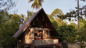 a small house with a black roof at Coffee Cabanas in Matale