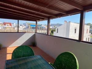 a balcony with a table and chairs on a roof at TANJALUCIA HOSTeL in Tangier