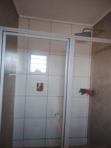 a shower with a glass door and a window at House in Pretoria