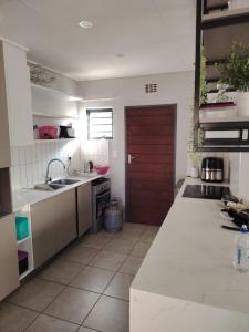 a kitchen with a sink and a red door at House in Pretoria