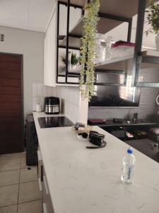 a kitchen with a white counter top with a bottle of water at House in Pretoria