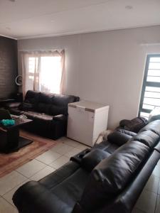 a living room with a black leather couch at House in Pretoria