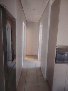 an empty hallway with white walls and a tile floor at House in Pretoria