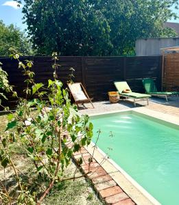 a swimming pool in a yard next to a fence at The Nook - Balatonkiliti in Siófok