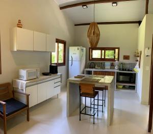 a kitchen with a refrigerator and a table and chairs at Casa Raiz 1 Moreré - A 3min da praia in Moreré +12 photos
