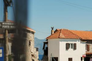 a building with a red tile roof in a city at BlueWave Apartments in Tivat