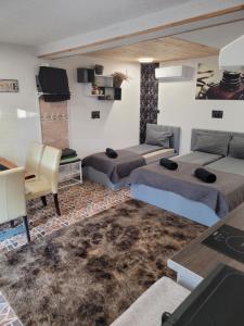 ein Zimmer mit zwei Betten, einem Tisch und einem Sofa in der Unterkunft Morrison Apartments in Miercurea Ciuc
