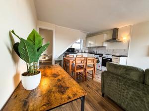 a kitchen and living room with a wooden table with a potted plant at The Lodge Mews in Shaw Mills