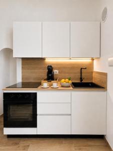 a kitchen with white cabinets and a sink at Domus Regina Sforza in Capurso